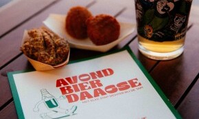 Bierglas en snacks op een tafel bij Avond Bierdaagse Amsterdam met stempelkaart.