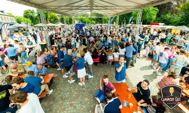 Grote menigte geniet van het Gimmert Gist Bierfestival onder een tent.