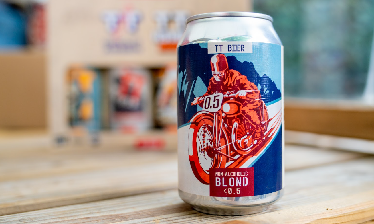 Blik TT Bier Non-Alcoholic Blond op houten tafel met achtergrond wat onscherp. 