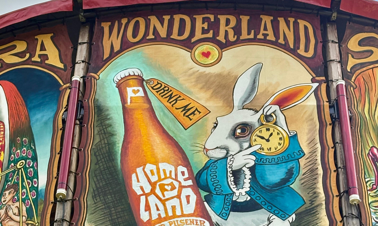 Schildering met een konijn en een bierfles van Brouwerij Homeland in Wonderland-thema.
